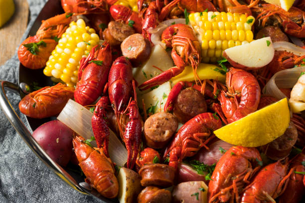 A vibrant seafood dish featuring crawfish, corn, potatoes, and sausage in a large serving bowl.