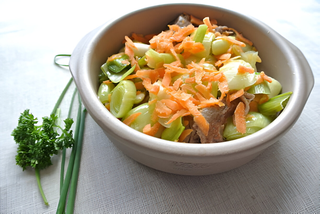 A bowl of stir-fried vegetables including green onions, carrots, and celery, garnished with fresh parsley.