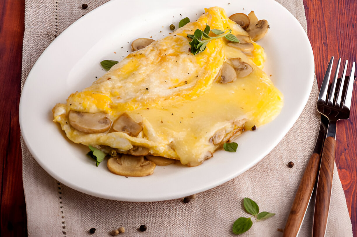 A delicious mushroom omelette served on a white plate, garnished with fresh herbs.
