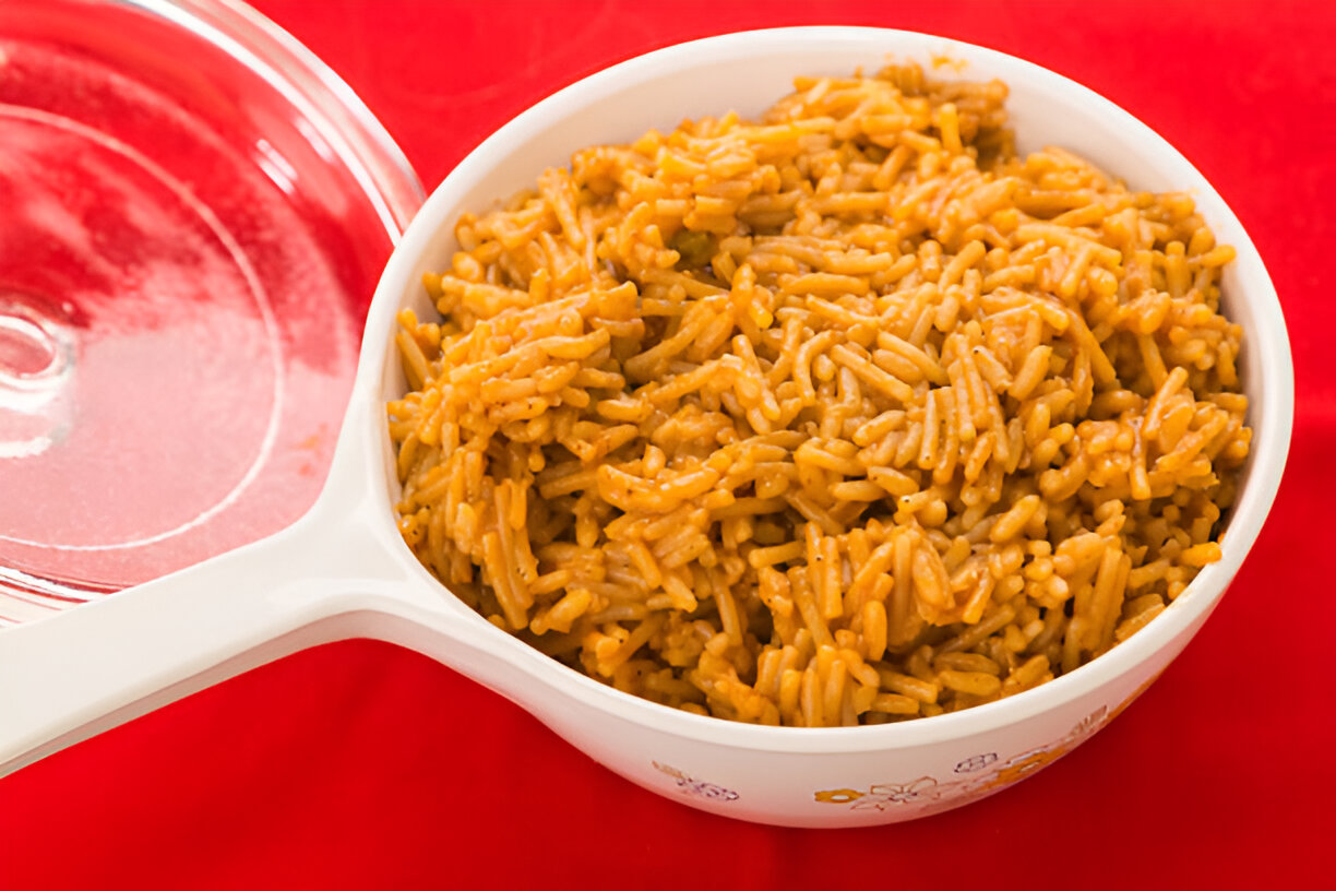 A serving of cooked rice in a bowl on a red background
