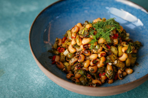 A bowl filled with a colorful salad made from black-eyed peas, vegetables, and herbs.