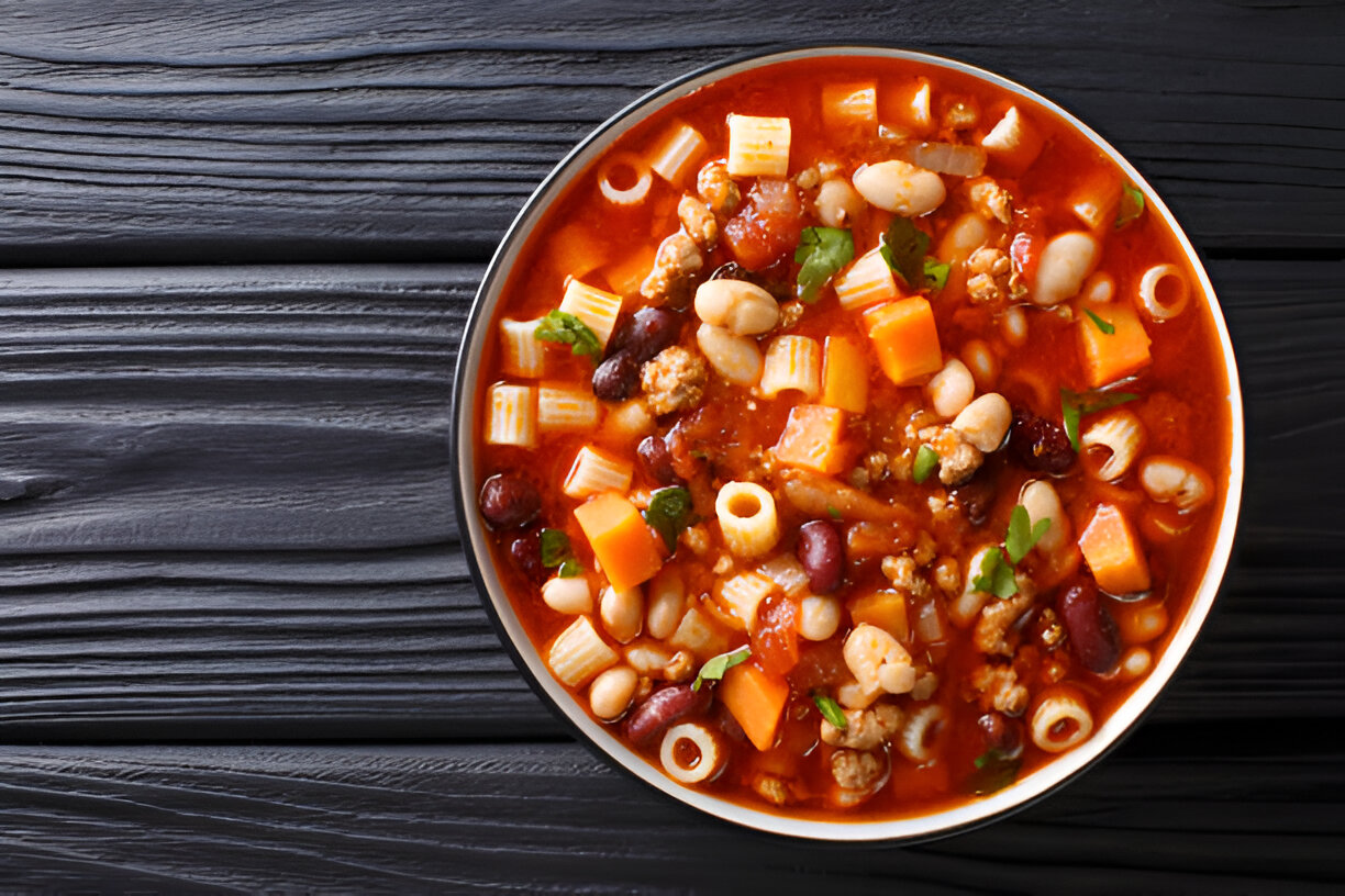 A warm bowl of hearty mixed bean soup with pasta and vegetables.