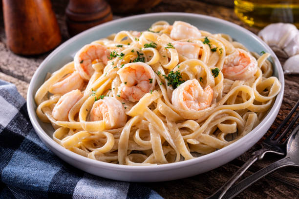 A plate of creamy shrimp fettuccine pasta topped with parsley.