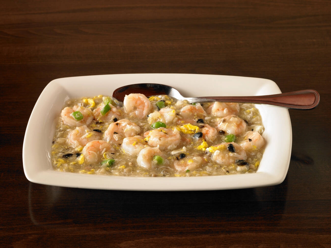 A serving of shrimp and rice dish on a white plate