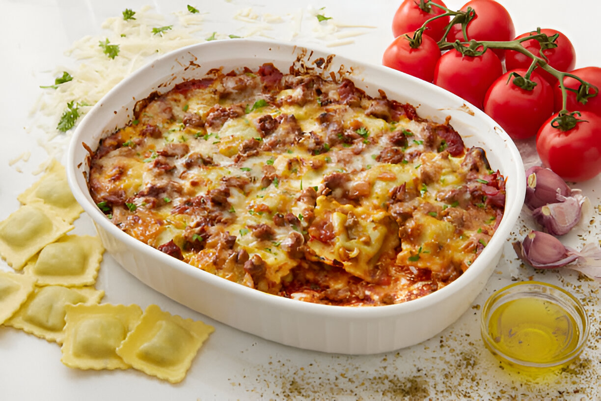 Baked ravioli casserole topped with melted cheese and fresh parsley, served with fresh tomatoes and garlic.