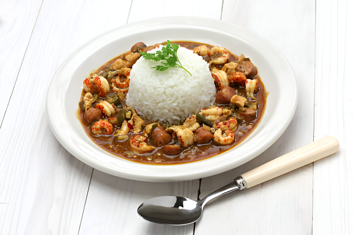 A plate of rice topped with a flavorful seafood and vegetable stew, garnished with a sprig of parsley.