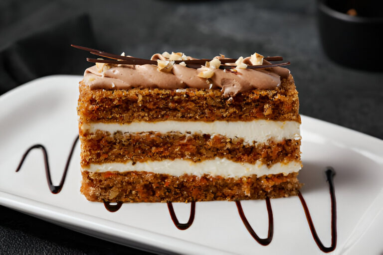 A slice of layered dessert on a white plate, drizzled with chocolate sauce.
