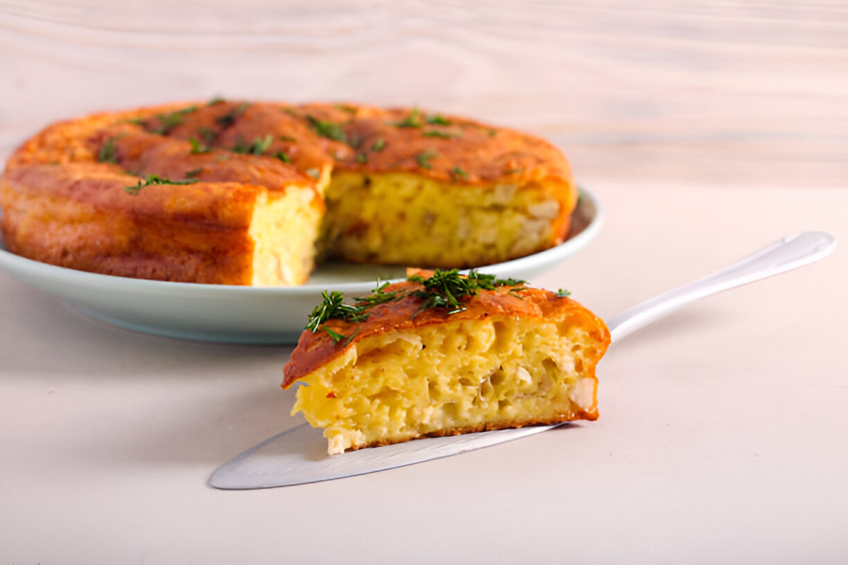 A sliced piece of savory cake showcasing its fluffy interior, garnished with herbs.