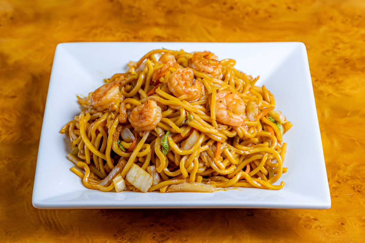 Delicious shrimp lo mein served in a white square plate.